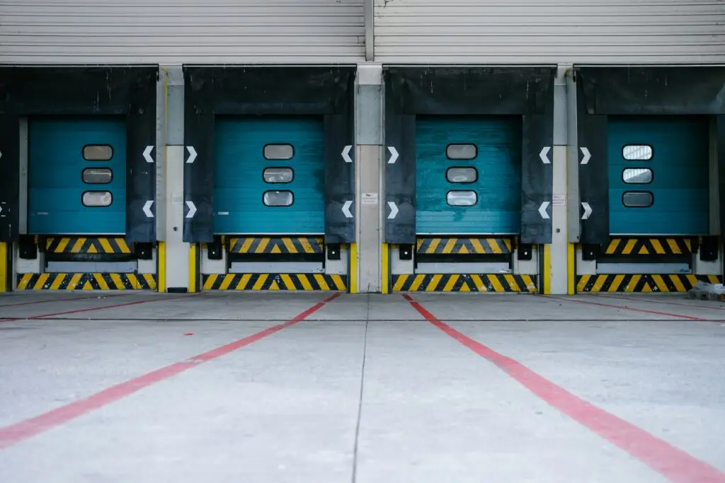 Warehouse loading dock with multiple closed bay doors and safety markings
